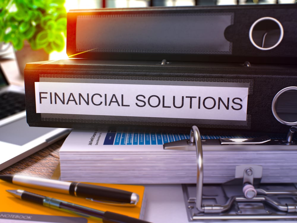 Black Office Folder with Inscription Financial Solutions on Office Desktop with Office Supplies and Modern Laptop. Financial Solutions Business Concept on Blurred Background. 3D Render.