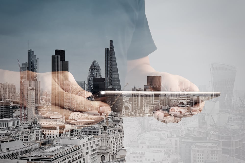 Double exposure of success businessman using digital tablet with london building and social media diagram