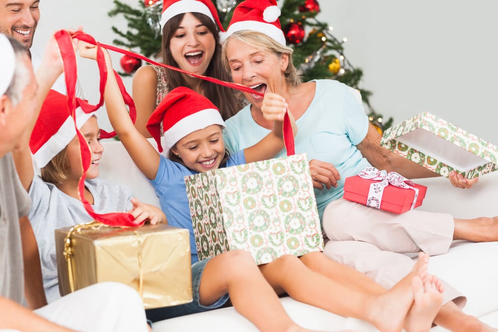Happy family at christmas opening gifts together on the couch