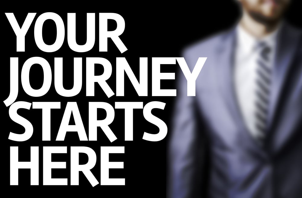 Your Journey Starts Here written on a board with a business man on background